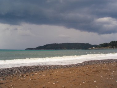 plaj, denize fırtına bulutu asılı