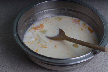 süt ve baharatlar ile bir tabak içinde kırık tavuk yumurtası. Bir omlet yapmak.