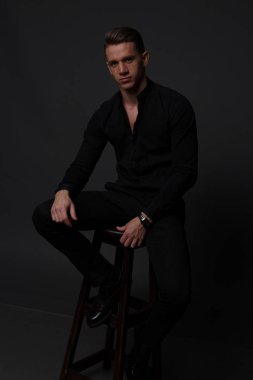 gri bir arka plan üzerinde çıplak bir gövde, beyaz pantolon ve beyaz gömlek, bir adamla standları