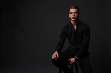 gri bir arka plan üzerinde çıplak bir gövde, beyaz pantolon ve beyaz gömlek, bir adamla standları