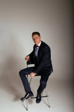 kıyafeti giyen bir sandalyede oturuyor