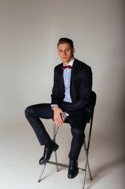 kıyafeti giyen bir sandalyede oturuyor