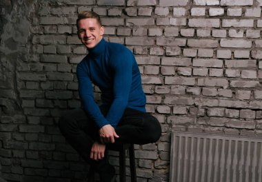 Genç adam oturuyor ve gülümsüyor