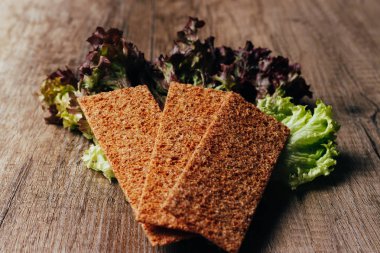 doğru beslenme kavramı: çavdar unu yalan ahşap bir masa üzerine salata ve rusk unundan