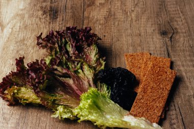 doğru beslenme kavramı: çavdar unu ve kuru erik salata ve rusk unundan yalan ahşap bir masaya