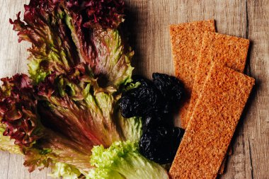 doğru beslenme kavramı: çavdar unu ve kuru erik salata ve rusk unundan yalan ahşap bir masaya