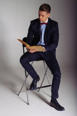 bir adam, bir mavi elbiseli bir adam bir sandalyeye oturur ve eski bir kitap okur, bilgi, eğitim, bilim, iş, her şey yeni, o iyi Unutulmuş eski bir kavramdır