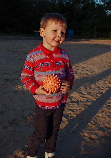 Kis vicces fiú, a narancssárga labdát, mosolyog — Stock Fotó
