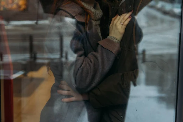 Un paio di abbracci. Una mano femminile con un anello giace sul petto di un uomo. un uomo abbraccia la vita di sua moglie. Fai capolino. vista dalla finestra — Foto Stock