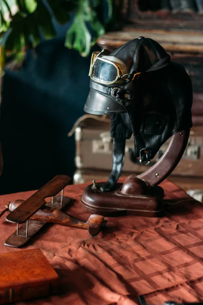 테이블에 놓여 조종사의 헬멧, 나무로 만든 장난감 비행기 — 스톡 사진