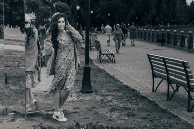 Saçlarını geliştirme yüzüne rüzgar, güzel kız köprüde duruyor. Kız gülümsüyor. siyah beyaz fotoğraf dans.