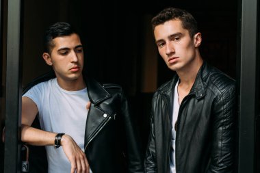 Güzel ve çekici bir adam şehirde poz veriyor. Siyah gözlüklerle şehirde dolaş. İletişim. arkadaşlarla buluş.