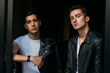 Güzel ve çekici bir adam şehirde poz veriyor. Siyah gözlüklerle şehirde dolaş. İletişim. arkadaşlarla buluş.