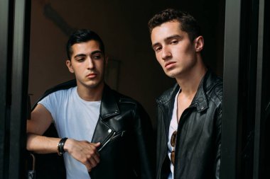 Güzel ve çekici bir adam şehirde poz veriyor. Siyah gözlüklerle şehirde dolaş. İletişim. arkadaşlarla buluş.