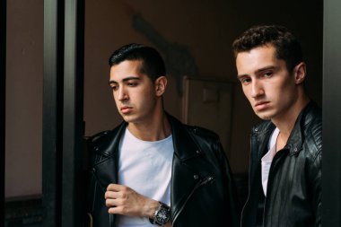 Güzel ve çekici bir adam şehirde poz veriyor. Siyah gözlüklerle şehirde dolaş. İletişim. arkadaşlarla buluş.