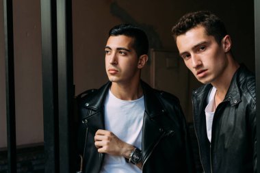 Güzel ve çekici bir adam şehirde poz veriyor. Siyah gözlüklerle şehirde dolaş. İletişim. arkadaşlarla buluş.