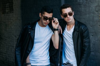 Güzel ve çekici bir adam şehirde poz veriyor. Siyah gözlüklerle şehirde dolaş. İletişim. arkadaşlarla buluş.