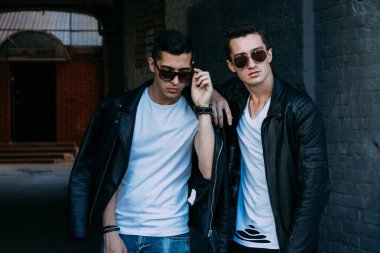 Güzel ve çekici bir adam şehirde poz veriyor. Siyah gözlüklerle şehirde dolaş. İletişim. arkadaşlarla buluş.