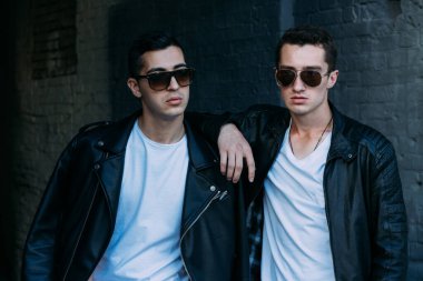 Güzel ve çekici bir adam şehirde poz veriyor. Siyah gözlüklerle şehirde dolaş. İletişim. arkadaşlarla buluş.