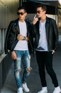 Güzel ve çekici bir adam şehirde poz veriyor. Siyah gözlüklerle şehirde dolaş. İletişim. arkadaşlarla buluş.