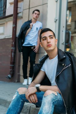 Güzel ve çekici bir adam şehirde poz veriyor. Siyah gözlüklerle şehirde dolaş. İletişim. arkadaşlarla buluş.