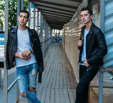 Güzel ve çekici bir adam şehirde poz veriyor. Siyah gözlüklerle şehirde dolaş. İletişim. arkadaşlarla buluş.