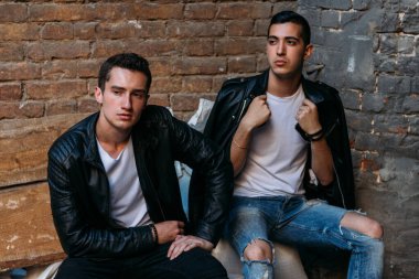 Güzel ve çekici bir adam şehirde poz veriyor. Siyah gözlüklerle şehirde dolaş. İletişim. arkadaşlarla buluş.