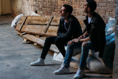 Güzel ve çekici bir adam şehirde poz veriyor. Siyah gözlüklerle şehirde dolaş. İletişim. arkadaşlarla buluş.