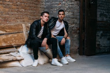 Güzel ve çekici bir adam şehirde poz veriyor. Siyah gözlüklerle şehirde dolaş. İletişim. arkadaşlarla buluş.