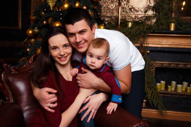 Hediye kutuları olan aile Noel ağacının yanında oturur, gülüp oynarlar, aile mutluluğu, şömine, kalplerin sıcaklığı.