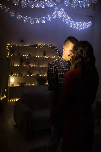 暗く暗い背景のクリスマスツリーのライトの愛のカップル、幸せ。クリスマスの夜新年。抱擁とキス魅力的ロマンチックな夜とデート. — ストック写真
