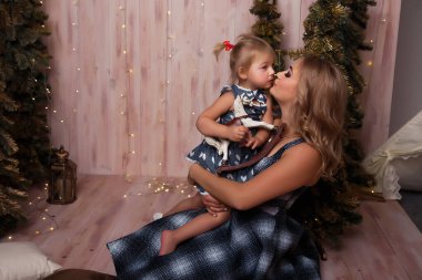 Gülümseyen anne kızıyla birlikte Noel ağacının yanında