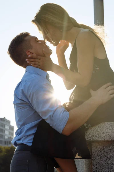 The couple kisses, and between them the rays of the sun, the sun, the light. attraction between a man and a woman. kiss in the sun. kiss the sun. between us is the sun. — Stock Photo, Image