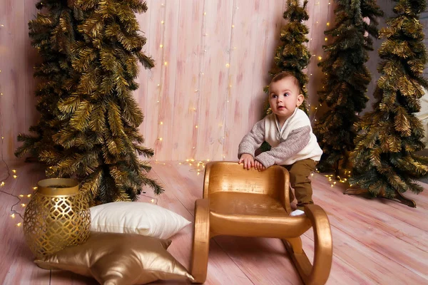 Um menino perto das árvores de Natal em um trenó, luzes de Natal, alegrias e sorrisos, peças de teatro. férias e férias — Fotografia de Stock