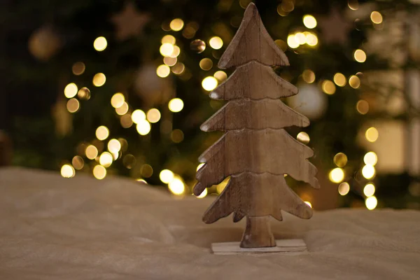 Árbol aserrado de madera, decoración, sobre el fondo de las luces del árbol de Navidad en la noche. Decoración de Navidad, regalo de Año Nuevo , — Foto de Stock