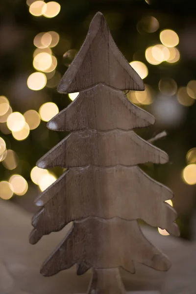 Árbol aserrado de madera, decoración, sobre el fondo de las luces del árbol de Navidad en la noche. Decoración de Navidad, regalo de Año Nuevo , — Foto de Stock