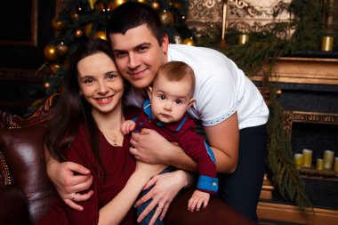 Hediye kutuları olan aile Noel ağacının yanında oturur, gülüp oynarlar, aile mutluluğu, şömine, kalplerin sıcaklığı.