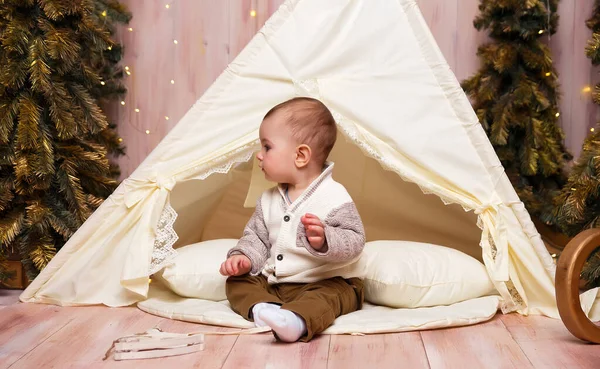 Un bambino vicino alla tenda, tipi, wigma e alberi di Natale, sta giocando . — Foto Stock