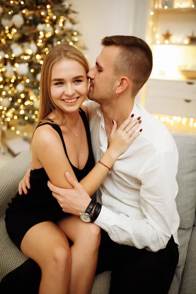 Casal no amor beijos e abraços no sofá perto das luzes da árvore de Natal. Noite de Ano Novo. Natal. . — Fotografia de Stock