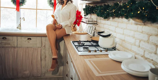 Menina na cozinha com uma camisa branca, perto da janela, segurando uma caneca. café da manhã, café da manhã, sexy — Fotografia de Stock