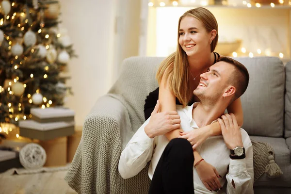 Casal no amor beijos e abraços no sofá perto das luzes da árvore de Natal. Noite de Ano Novo. Natal. . — Fotografia de Stock