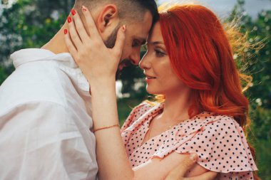 Mutlu, birbirine aşık çiftler, kızıl kız. Öpüşmeye bir dakika. tarih