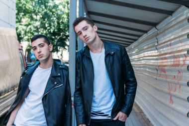 Güzel ve çekici bir adam şehirde poz veriyor. Siyah gözlüklerle şehirde dolaş. İletişim. arkadaşlarla buluş.