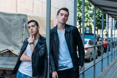 Güzel ve çekici bir adam şehirde poz veriyor. Siyah gözlüklerle şehirde dolaş. İletişim. arkadaşlarla buluş.