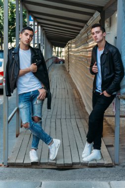 Güzel ve çekici bir adam şehirde poz veriyor. Siyah gözlüklerle şehirde dolaş. İletişim. arkadaşlarla buluş.