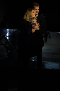 Geceler, yağmurlar, şehirdeki binalar, gülücükler, cazibe. Adam kıza sarılıyor. Sevgililer Günü