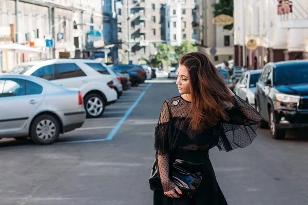 Ritratto di una ragazza, bruna, in abito nero, nell'arco, in città. posare, camminare. solo nella folla, solitudine — Foto Stock