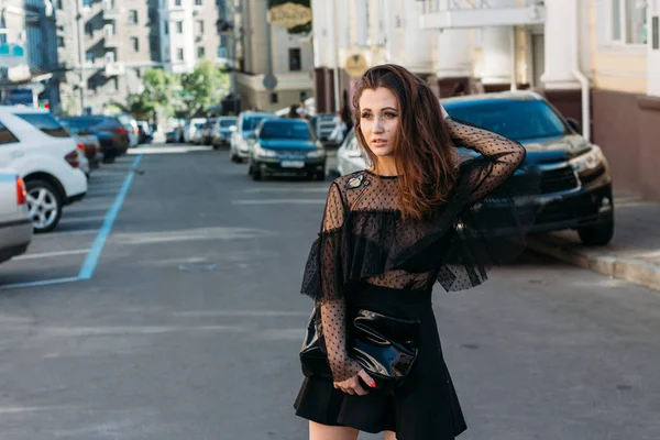 Portrait of a girl, brunette, in a black dress, in the arch, in the city. posing, walking. alone in the crowd, loneliness — 스톡 사진