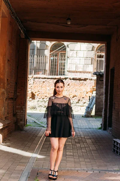 The girl is posing smiles. Emotional portrait of Fashion stylish portrait of pretty young woman. city portrait. brunette in a black dress. expectation. dreams — Stock Photo, Image