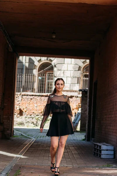 The girl is posing smiles. Emotional portrait of Fashion stylish portrait of pretty young woman. city portrait. brunette in a black dress. expectation. dreams — Stock Photo, Image